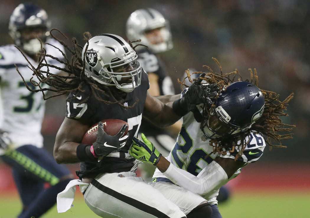Oakland Raiders wide receiver Dwayne Harris (17), left, is challenged by Seattle Seahawks cornerback Shaquill Griffin (26) during the first half of an NFL football game at Wembley stadium in Londo ...