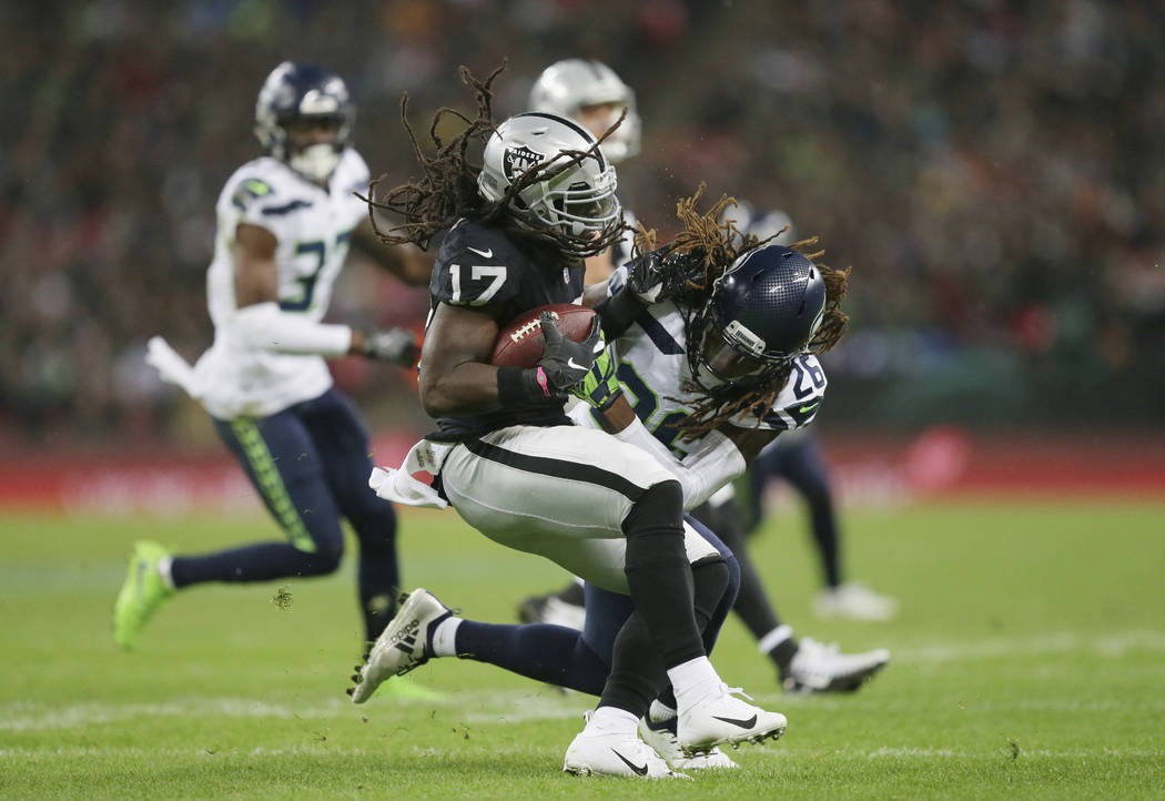 Oakland Raiders wide receiver Dwayne Harris (17), left, is challenged by Seattle Seahawks cornerback Shaquill Griffin (26) during the first half of an NFL football game at Wembley stadium in Londo ...
