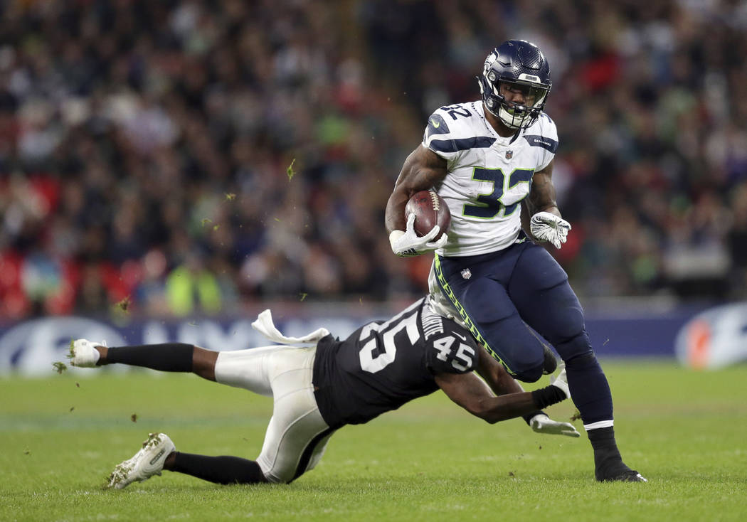 Seattle Seahawks running back Chris Carson (32) runs clear of Oakland Raiders defensive back Dominique Rodgers-Cromartie (45) during the second half of an NFL football game at Wembley stadium in L ...