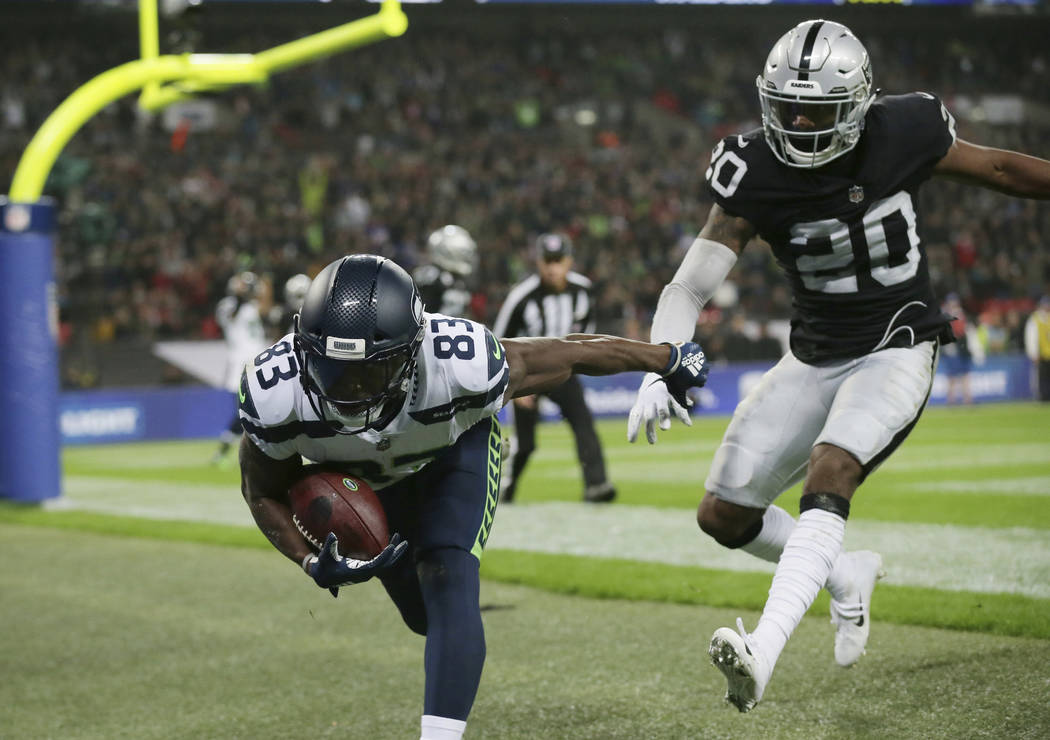 Seattle Seahawks wide receiver David Moore (83) stumbles out of the end zone after scoring a touchdown during the first half of an NFL football game at Wembley stadium in London, Sunday, Oct. 14, ...