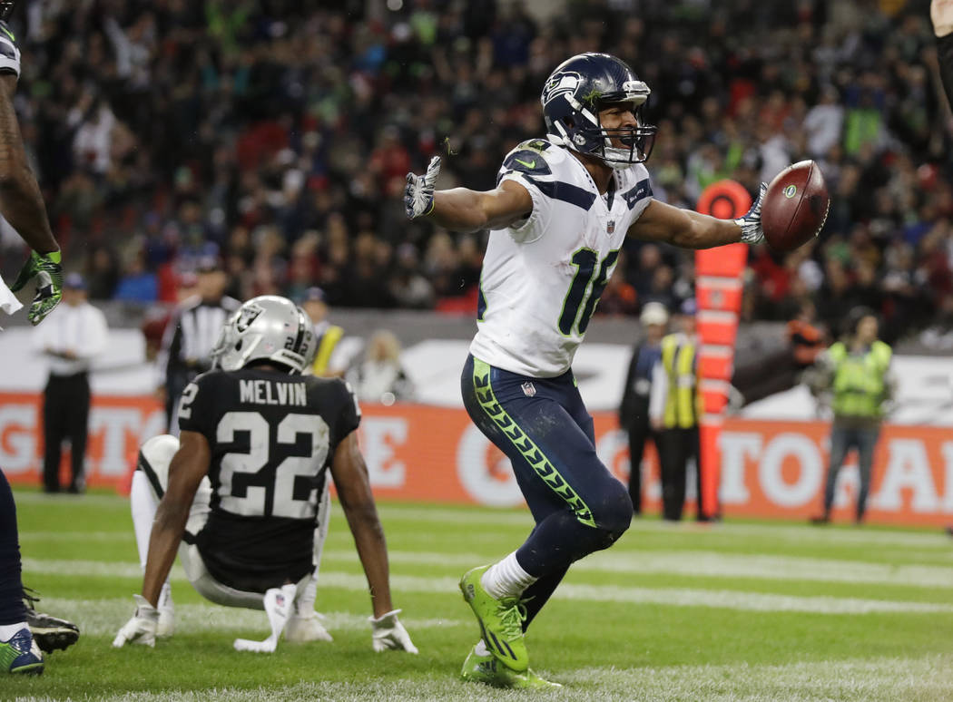 Seattle Seahawks wide receiver Tyler Lockett (16) celebrates after scoring a touchdown during the second half of an NFL football game against Oakland Raiders at Wembley stadium in London, Sunday, ...