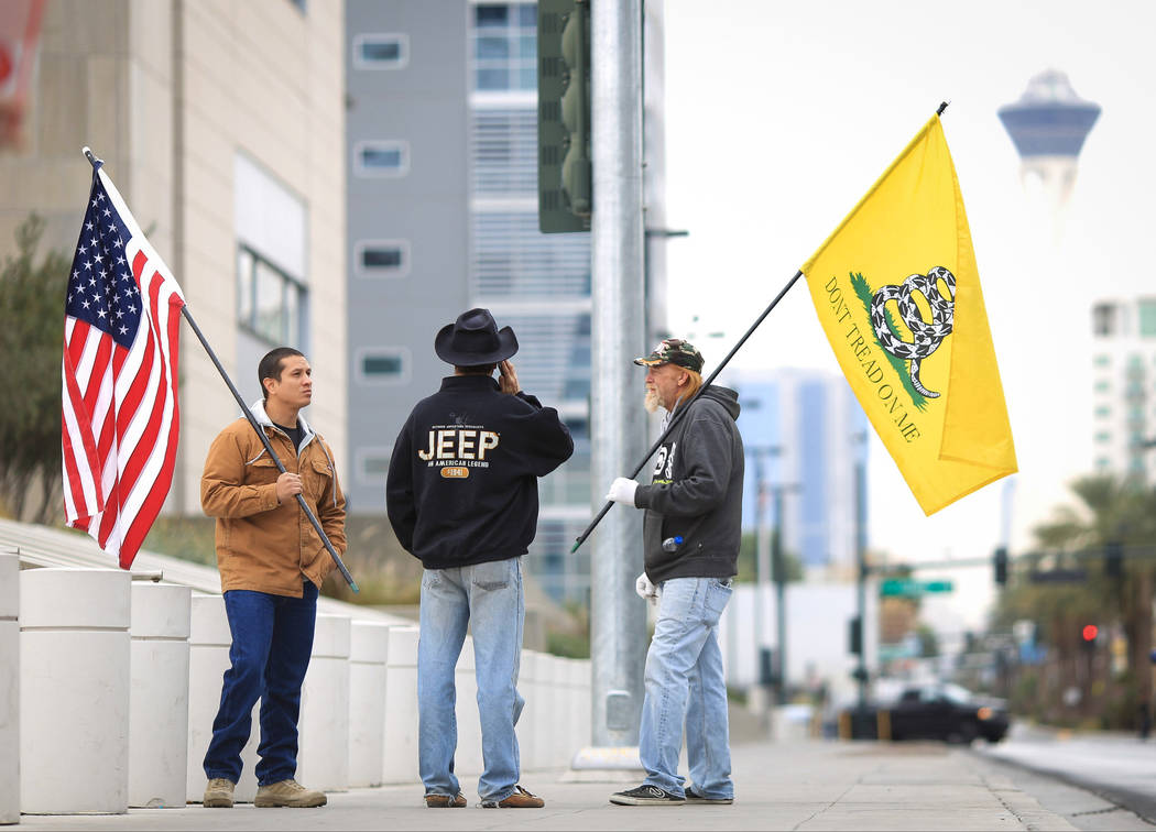 Joshua Martinez, left, Greg Whalen, center, and Michael Elliot, stand outside of the Lloyd D. George Courthouse to demonstrate their support for the Bundy family in Las Vegas on Friday, Dec. 9, 20 ...