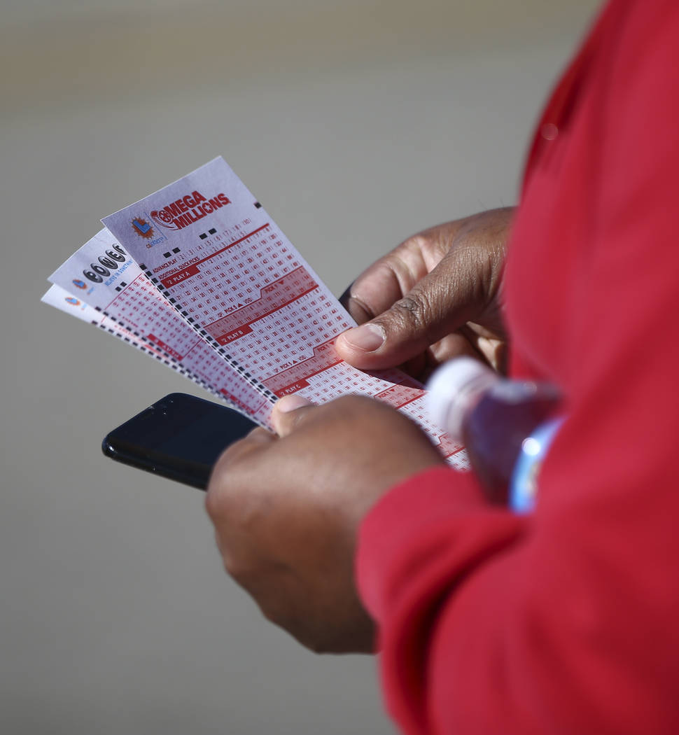 A man holds a Mega Millions form as hundreds line up outside of the Primm Valley Lotto Store as people wait to buy the Mega Millions lottery tickets in Primm on Thursday, Oct. 18, 2018. Chase Stev ...
