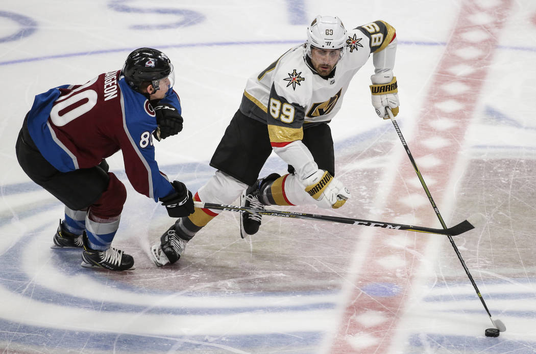 Vegas Golden Knights right wing Alex Tuch (89) moves the puck past Colorado Avalanche center Brandon Saigeon (80) during the first period of a preseason NHL hockey game Tuesday, Sept. 18, 2018, in ...