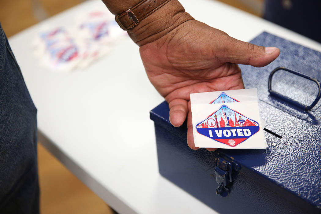 Poll worker Myron Wilson holds "I Voted" stickers at the East Las Vegas Community Center in Las Vegas, Saturday, Oct. 20, 2018. Erik Verduzco Las Vegas Review-Journal @Erik_Verduzco