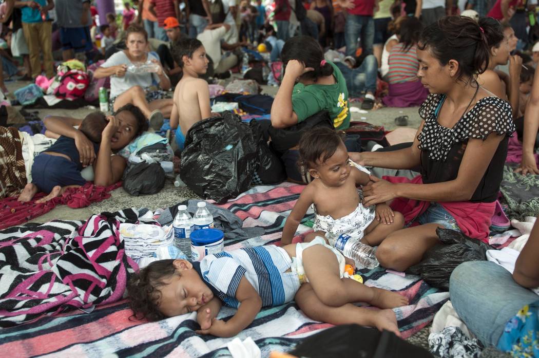 A group of migrants rests at the central park in Ciudad Hidalgo, Mexico, Saturday, Oct. 20, 2018. About 2,000 Central American migrants who circumvented Mexican police at a border bridge and swam, ...
