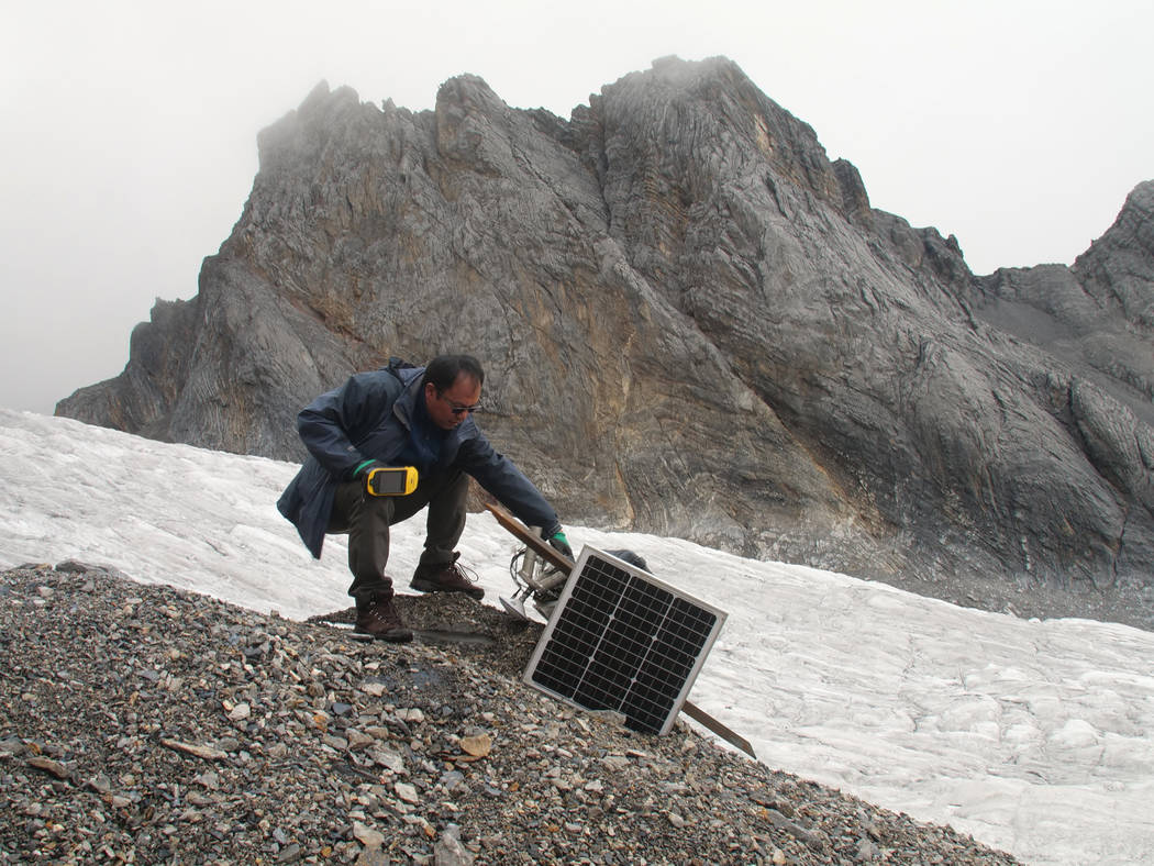 This Sept. 22, 2018 photo shows glaciologist Wang Shijin repairing a broken remote meteorological station on the Baishui Glacier No. 1 on the Jade Dragon Snow Mountain in the southern province of ...