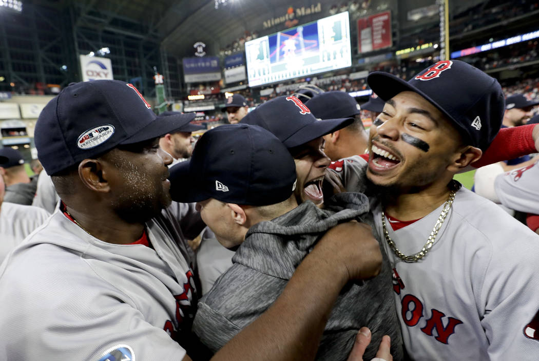 Boston Red Sox right fielder Mookie Betts, right, celebrates after they won the baseball American League Championship Series against the Houston Astros on Thursday, Oct. 18, 2018, in Houston. Red ...