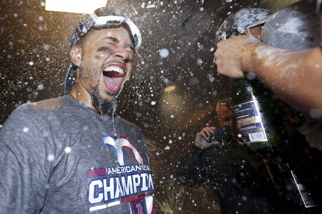 Boston Red Sox right fielder Mookie Betts celebrates in the locker room after winning the baseball American League Championship Series against the Houston Astros on Thursday, Oct. 18, 2018, in Hou ...