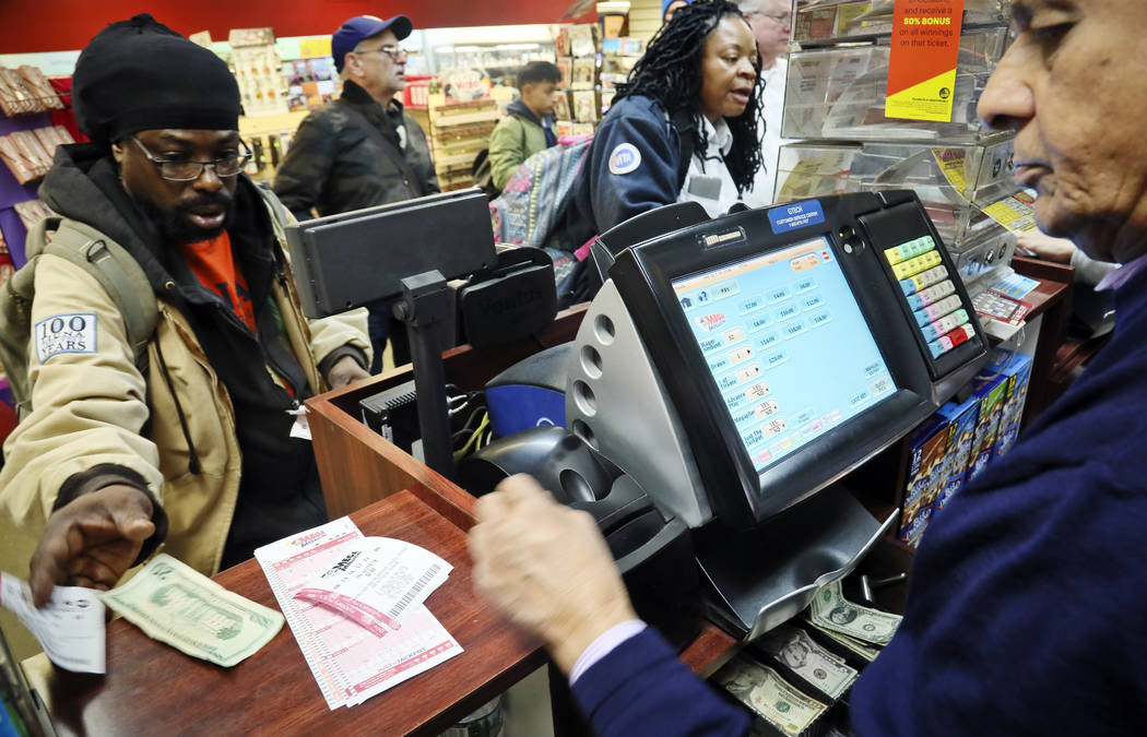 Lottery players buy Mega Millions lottery tickets Friday Oct. 19, 2018, in New York. The estimated jackpot for Friday's drawing has soared to $1 billion. (AP Photo/Bebeto Matthews)