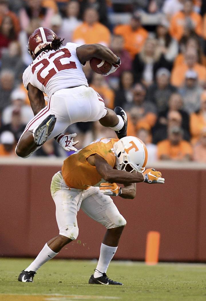 Alabama running back Najee Harris (22) hurtles over Tennessee defensive back Nigel Warrior (18) as he runs toward the end zone during the second half of an NCAA college football game Saturday, Oct ...