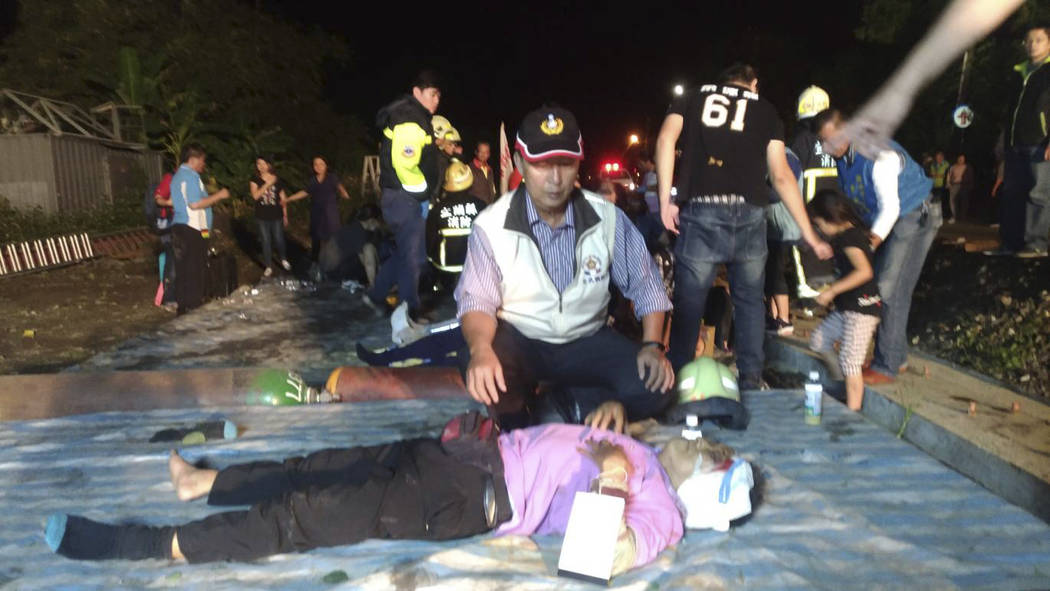 In this photo released by Military News Agency, rescue workers tend to the injured at the site of a train derailment in Lian in northern Taiwan on Sunday, Oct. 21 2018. The Puyuma express train wa ...