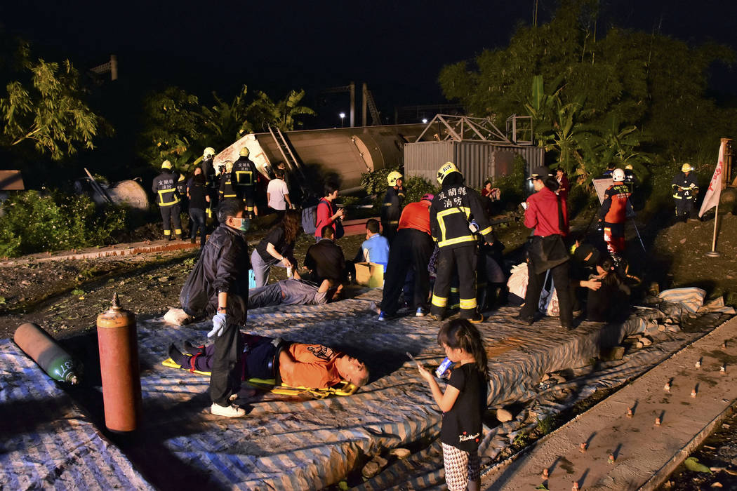 Rescue workers tend to the injured at the site of a train derailment in Lian county in northern Taiwan on Sunday, Oct. 21, 2018. Passengers were killed and injured on Sunday when one of Taiwan's n ...