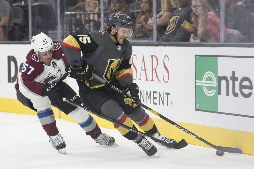 Golden Knights defenseman Jake Bischoff (45) fights for possession with Colorado Avalanche left wing Gabriel Bourque (57) in the first period during their NHL preseason matchup on Monday, Sept. 24 ...