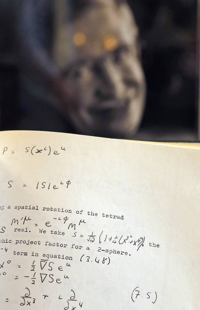 A Book, written and corrected with handwritten annotation by Stephen Hawking is one of the personal and academic possessions of Stephen Hawking, photo behind, on display at the auction house Chris ...