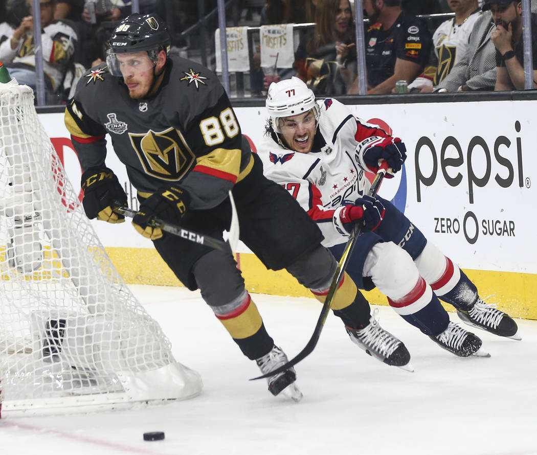 Golden Knights defenseman Nate Schmidt (88) moves the puck while being chased after by Washington Capitals right wing T.J. Oshie (77) during the second period of Game 2 of the NHL hockey Stanley C ...