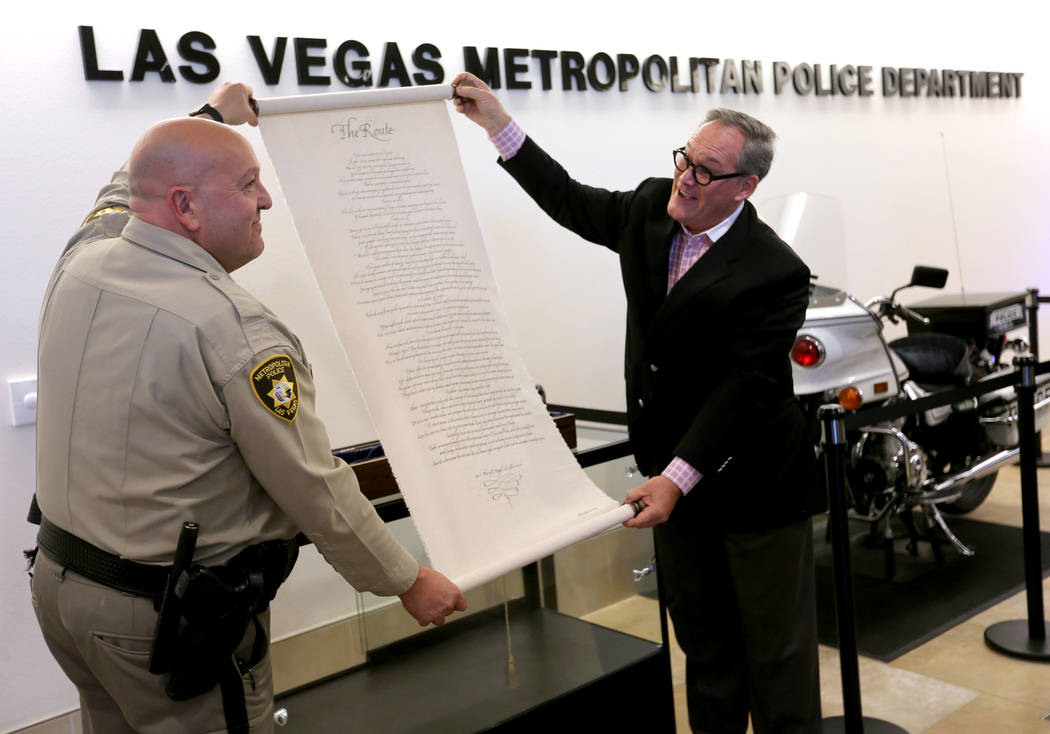 Las Vegas police Lt. Harry Fagel and Nevada School of the Arts President and CEO Patrick Duffy unveil "The Route" poem scroll at Metropolitan Police Department headquarters in Las Vegas Thursday, ...