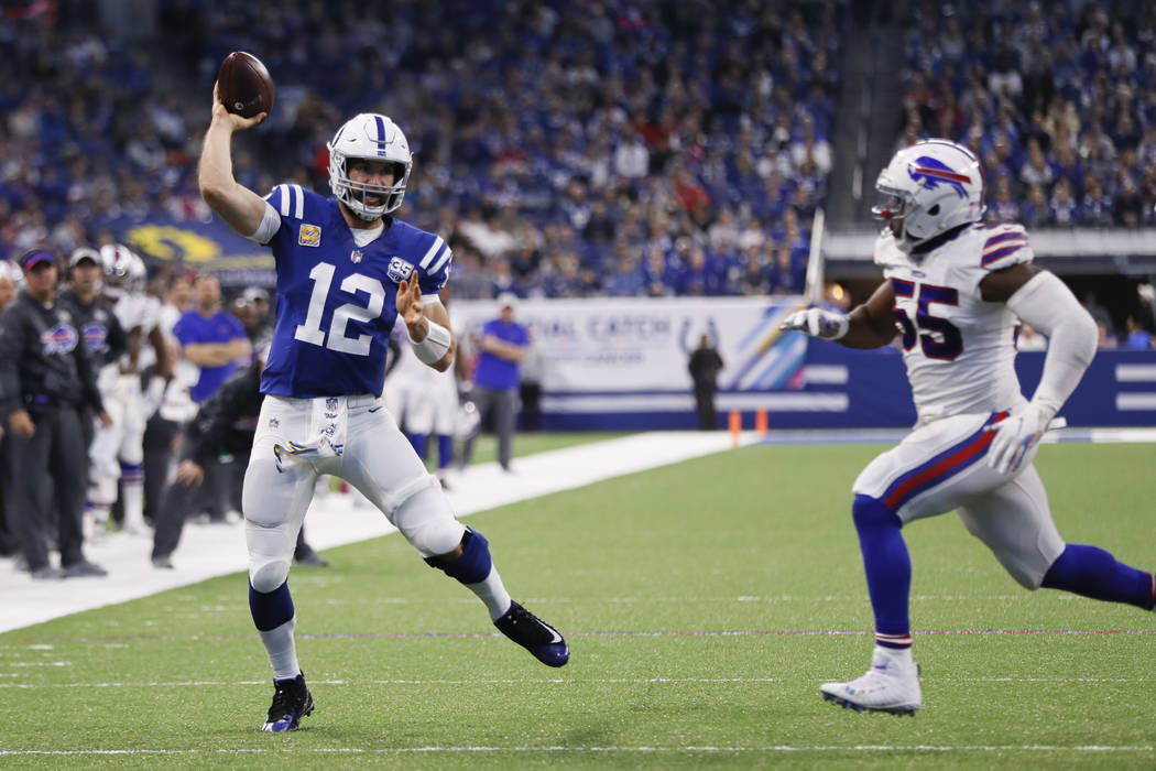 Indianapolis Colts quarterback Andrew Luck (12) throws a pass for a touchdown in front of Buffalo Bills defensive end Jerry Hughes (55) during the first half of an NFL football game in Indianapoli ...