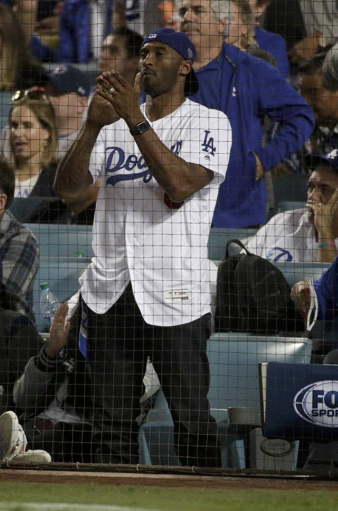 Former Los Angeles Laker Kobe Bryant watches during the eighth inning in  Game 4 of the World Series baseball game between the Los Angeles Dodgers  and the Boston Red Sox on Saturday