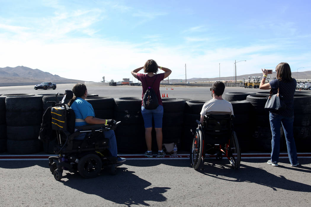 Spectators watch the raceway at an event for Driven, a new rehabilitation center to help people with disabilities that will be built in downtown Las Vegas at SpeedVegas in Las Vegas, Sunday, Oct. ...