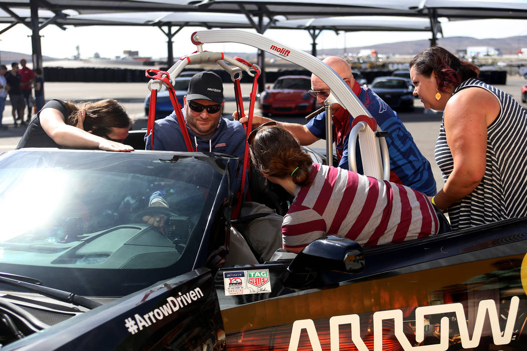 Friends and family assist Janne Kouri at an event for Driven, a new rehabilitation center to help people with disabilities that will be built in downtown Las Vegas at SpeedVegas in Las Vegas, Sund ...