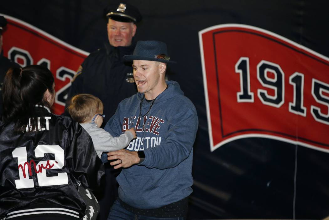 Boston Red Sox's Brock Holt reaches for his son Griffin as he arrives back  in Boston with his family, Monday, Oct. 29, 2018. The Red Sox defeated the  Los Angeles Dodgers on