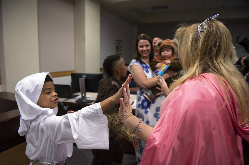 Jaelyn Elliott, 7, high fives District Court Family Judge Cynthia Giuliani after swearing in her new adopted family member Connor, 1, at Family Court in Las Vegas, Wednesday, Oct. 31, 2018. Caroli ...
