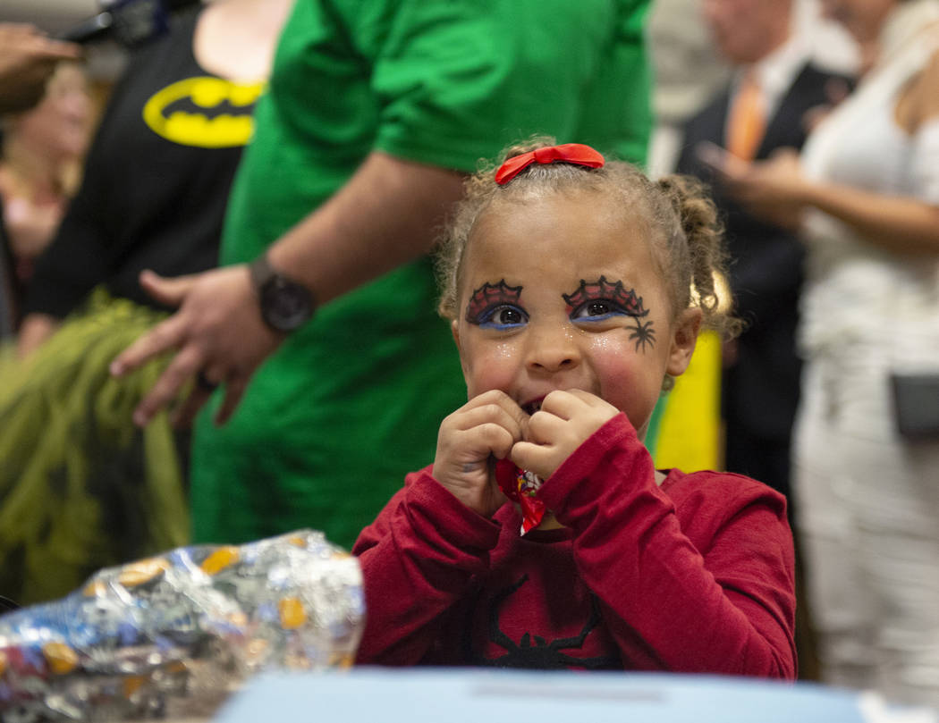 New adopted family member Malakai Lawter, 1, eats a piece of candy after she and her brother and sister are sworn in by District Court Family Judge Cynthia Giuliani at Family Court in Las Vegas, W ...