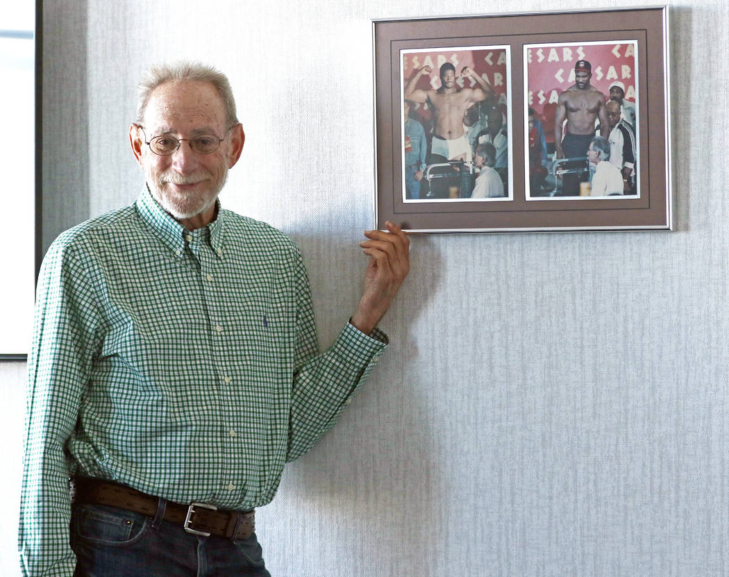 Marc Ratner, former executive director of the Nevada Athletic Commission, shows a weigh-in photo that hangs in his office at the UFC headquarters from the Riddick Bowe-Evander Holyfield rematch on ...