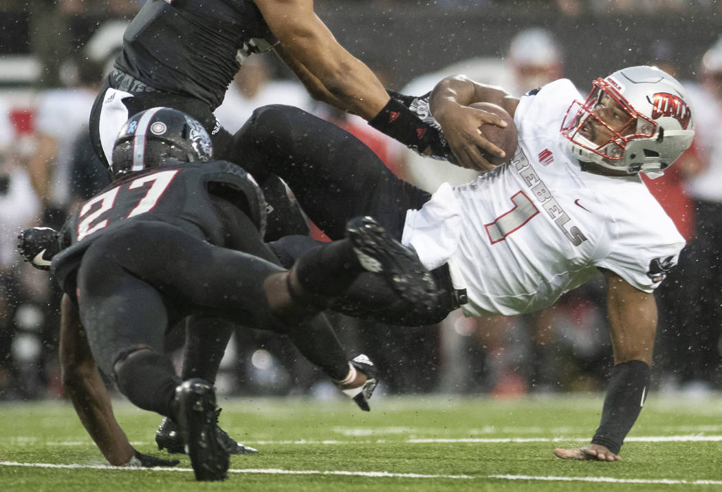 UNLV quarterback Armani Rogers (1) is brought to the ground by Arkansas State linebacker Caleb Bonner (22) and defensive back Demari Medley (27) during an NCAA college football game Saturday, Sept ...