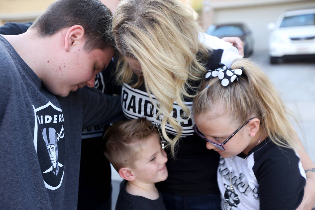 The Tracy family, from left, Colin Tracy, 17, Meredith Tracy, Kannon Tracy, 5, and Callie Tracy, 9, embrace after releasing balloons in honor of Russell Tracy's birthday outside their home in Las ...