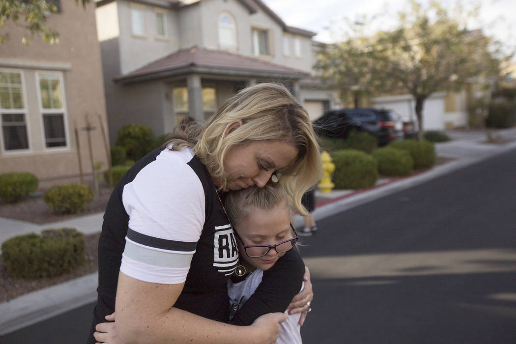 Meredith Tracy embraces her daughter Callie Tracy, 9, after releasing balloons in honor of Russell Tracy's birthday outside their home in Las Vegas, Friday, Nov. 2, 2018. Russell Tracy was killed ...