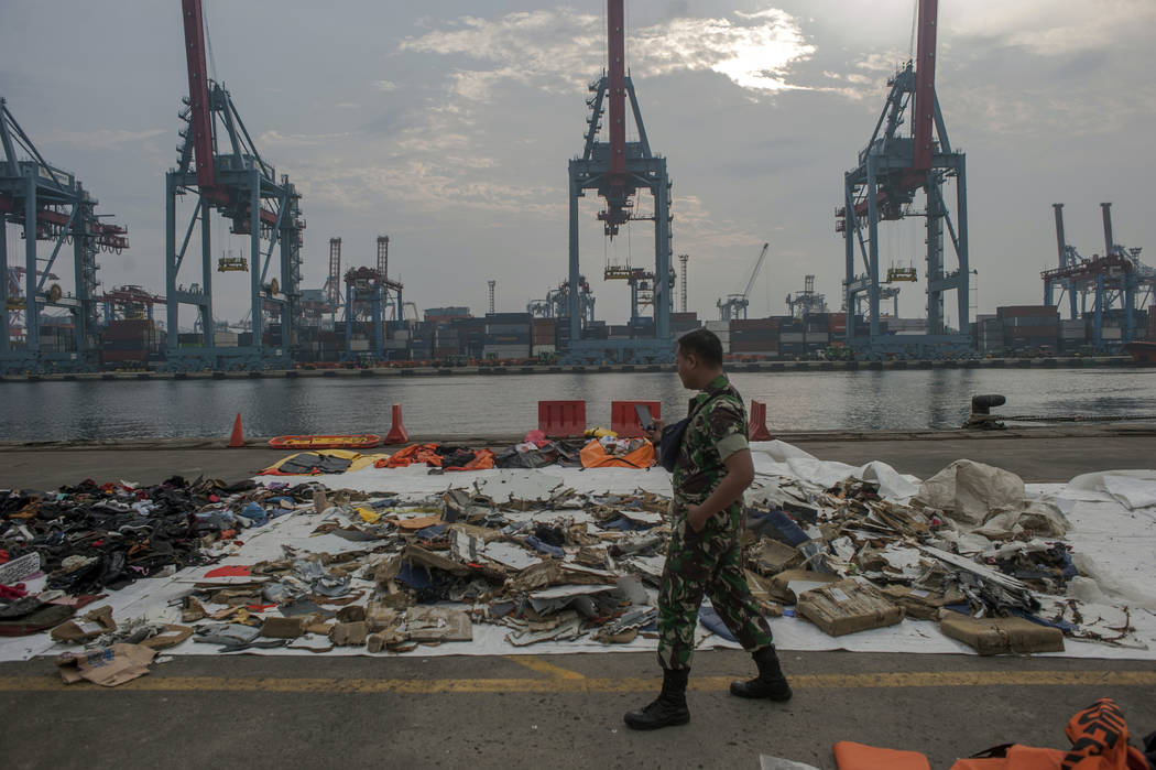 An Indonesian soldiers walk past debris retrieved from the waters where Lion Air flight JT 610 is believed to have crashed at Tanjung Priok Port in Jakarta, Indonesia, Wednesday, Oct. 31, 2018. A ...