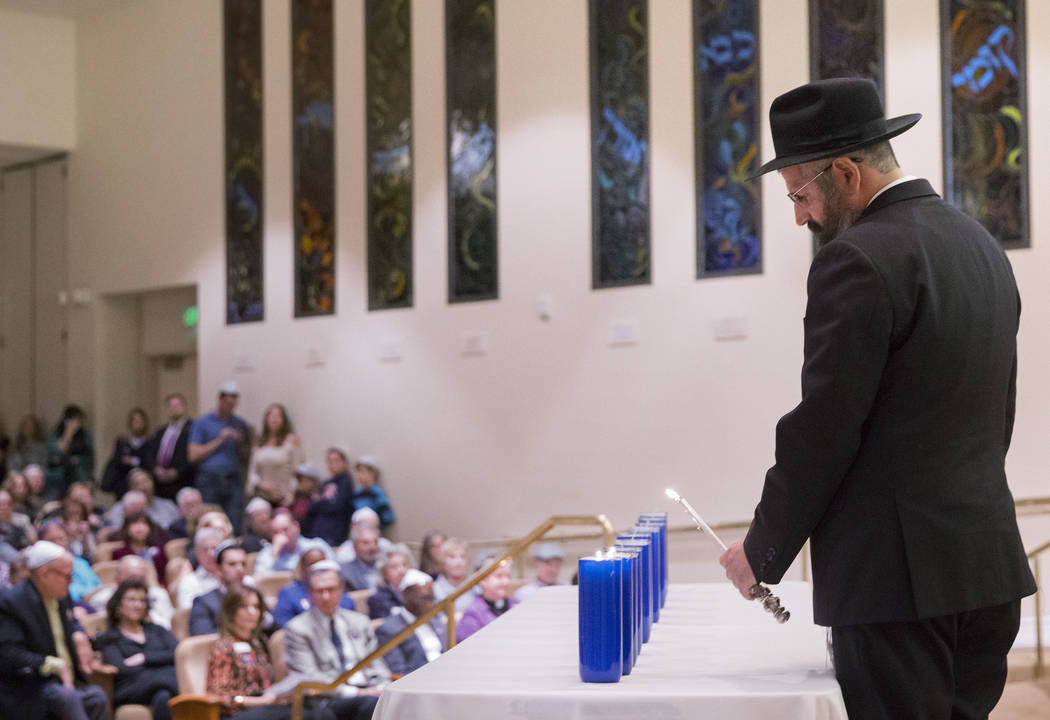 Rabbi Mendy Harlig lights a candle during a vigil on Thursday, November 1, 2018, at Temple Beth Sholom in Las Vegas for the 11 people killed at the Tree of Life synagogue in Pittsburgh, Pa., on Sa ...