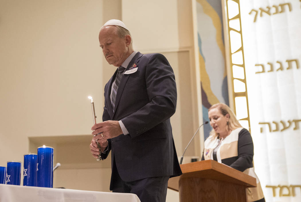 Pastor David Shearin, left, lights a candle during a vigil on Thursday, November 1, 2018, at Temple Beth Sholom in Las Vegas for the 11 people killed at the Tree of Life synagogue in Pittsburgh, P ...