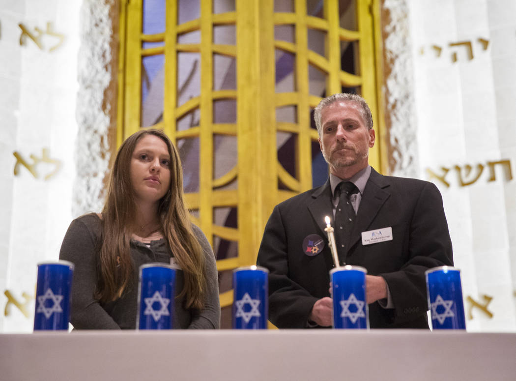 Ken Moskowitz, right, and Ari Goodman light candles during a vigil on Thursday, November 1, 2018, at Temple Beth Sholom in Las Vegas for the 11 people killed at the Tree of Life synagogue in Pitts ...