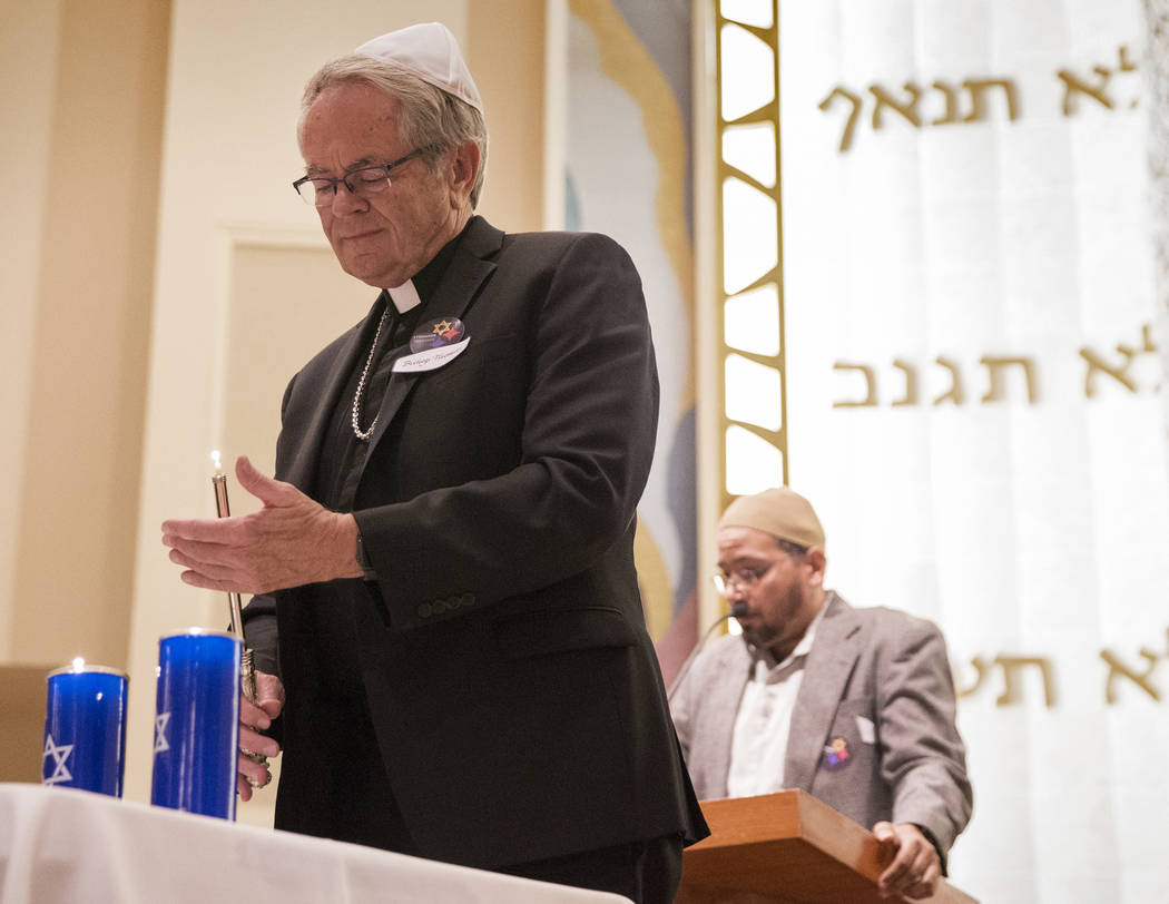 Bishop George Leo Thomas lights a candle during a vigil on Thursday, November 1, 2018, at Temple Beth Sholom in Las Vegas for the 11 people killed at the Tree of Life synagogue in Pittsburgh, Pa., ...