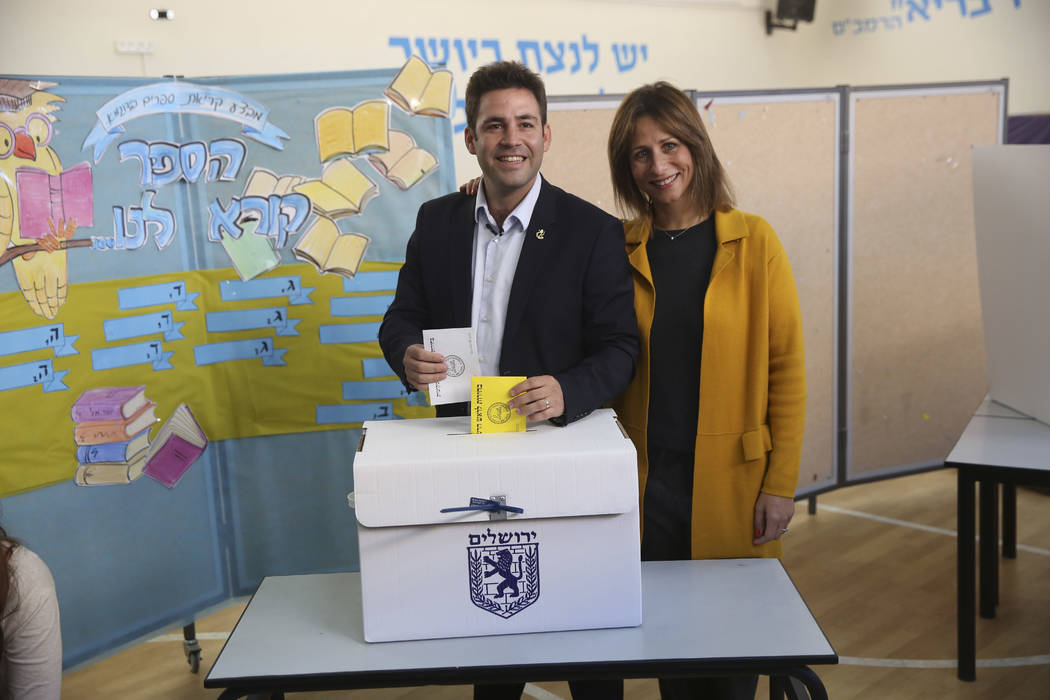 Mayoral candidate Ofer Berkovitch and his wife Dina pose for media as they cast their votes at a polling station during the municipal elections in Jerusalem, Tuesday, Oct. 30, 2018. (AP Photo/Oded ...