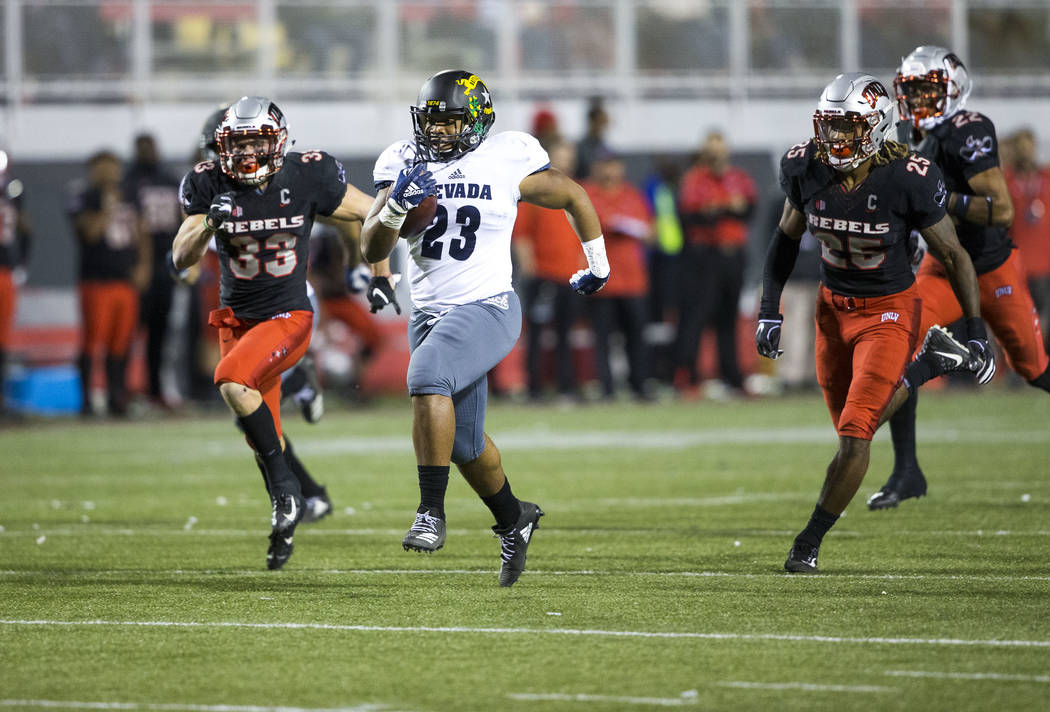 Nevada Wolf Pack running back Kelton Moore (23) breaks past UNLV Rebels defenders for a touchdown during the first half of a NCAA football game at Sam Boyd Stadium in Las Vegas on Saturday, Nov. 2 ...