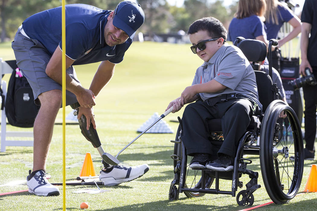 Shriners Hospital celebrity patient Alec Cabacungan, 16, putts while getting some pointers from US Adaptive Golf Alliance trainer John Bell during a golf clinic on day two of the Shriners Hospital ...