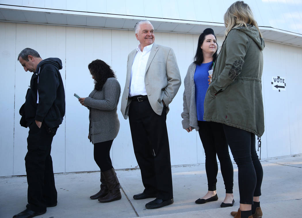 Steve Sisolak, center, Democratic candidate for Nevada Governor, with his two daughters Ashley and Carley, wait in line to cast their vote at a polling station at Kenny Guinn Middle School in Las ...