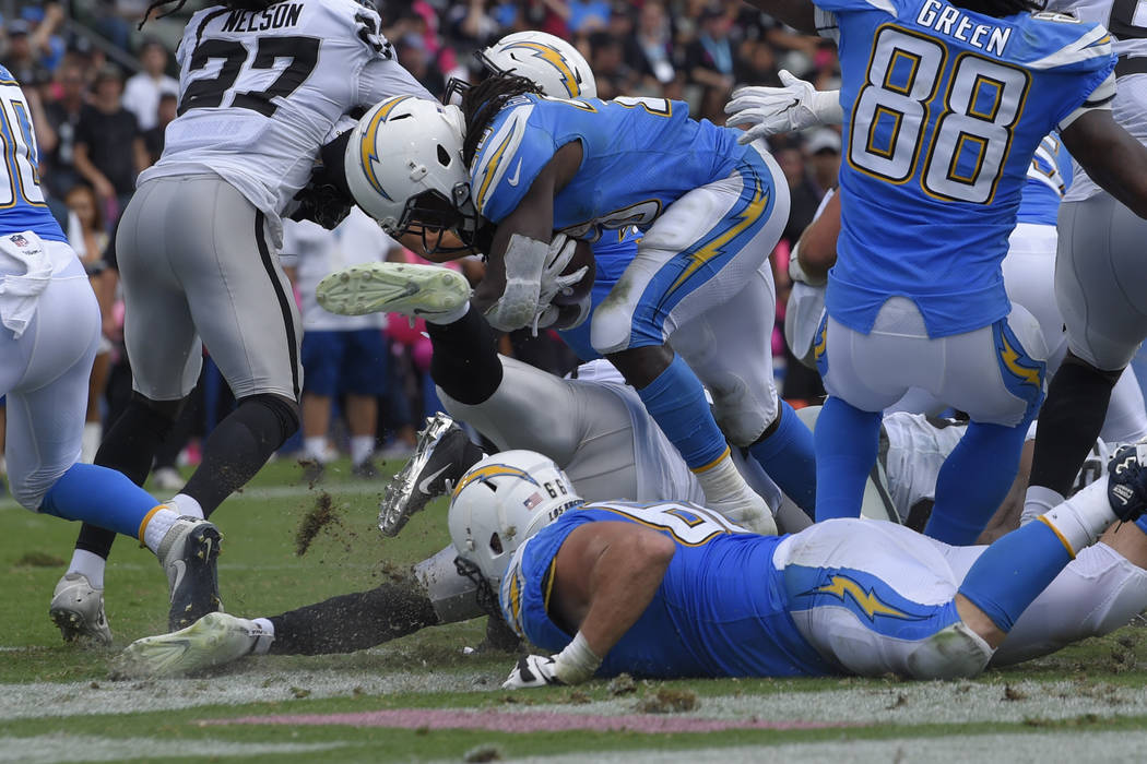Los Angeles Chargers running back Melvin Gordon, center, scores a touchdown during the first half of an NFL football game against the Oakland Raiders Sunday, Oct. 7, 2018, in Carson, Calif. (AP Ph ...