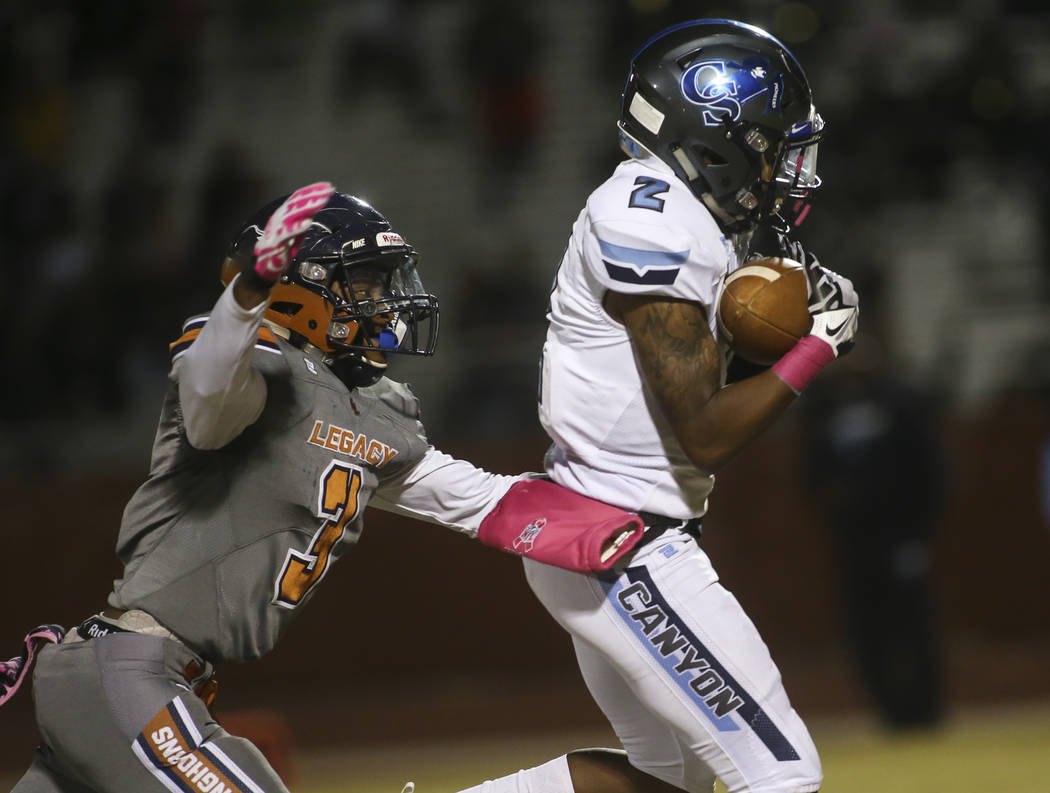 Canyon Springs' Shakureon Dukes (2) pulls in a reception in front of Legacy's Anthony Myles (3) during the first half of a football game at Legacy High School in North Las Vegas on Thursday, Oct. ...