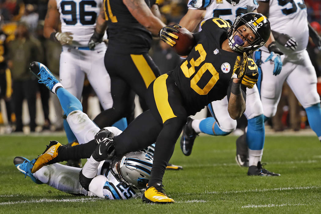 Pittsburgh Steelers running back James Conner (30) is tackled by Carolina Panthers strong safety Eric Reid (25) during the first half of an NFL football game in Pittsburgh, Thursday, Nov. 8, 2018. ...
