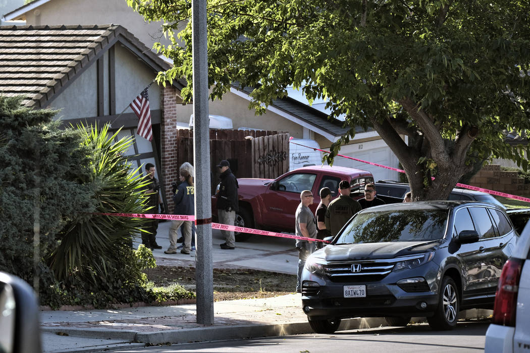 Ventura County Sheriff's deputies and FBI investigators stand outside the house of shooting suspect David Ian Long in Newbury Park, Calif., on Thursday, Nov. 8, 2018. Authorities said the former M ...