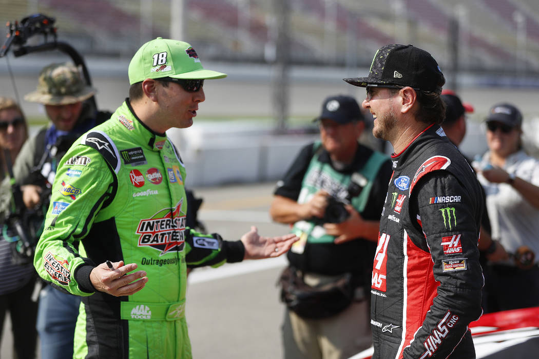 Kyle Busch, left, talks with his brother Kurt Busch before qualifications for a NASCAR Cup Series auto race at Michigan International Speedway in Brooklyn, Mich., Friday, Aug. 10, 2018. (AP Photo/ ...