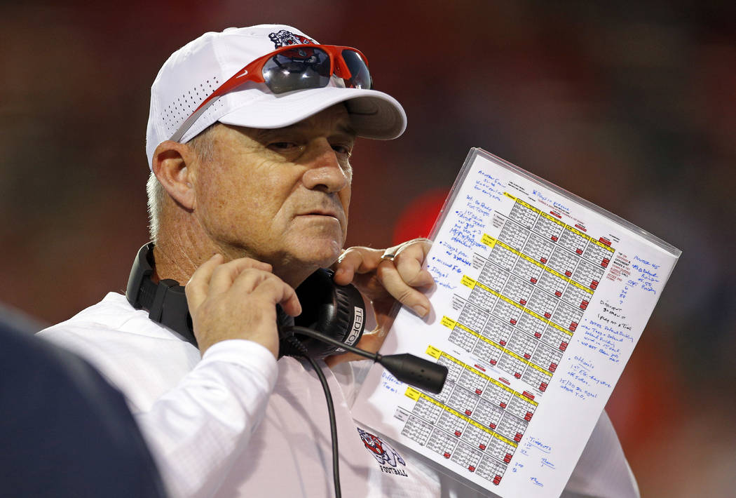 Fresno State coach Jeff Tedford adjusts his headphones during the first half of an NCAA college football game against New Mexico in Albuquerque, N.M., Saturday, Oct. 20, 2018. (AP Photo/Andres Lei ...