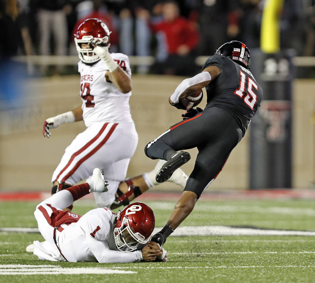 Texas Tech's Vaughnte Dorsey (15) breaks a tackle by Kyler Murray (1) after intercepting his pass during the first half of an NCAA college football game Saturday, Nov. 3, 2018, in Lubbock, Texas. ...