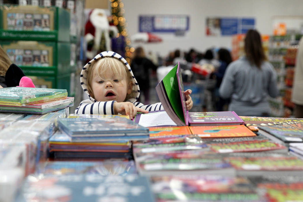 Kaydence Wood, 2, checks out books at the grand opening of Costco near the intersection of St. Rose Parkway and Amigo Street in Henderson Thursday, Nov. 8, 2018. K.M. Cannon Las Vegas Review-Journ ...