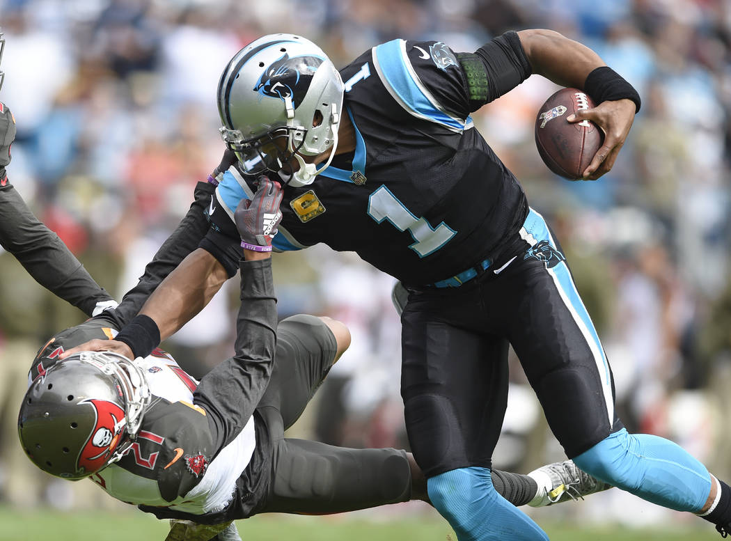 Tampa Bay Buccaneers' Justin Evans (21) grabs the face mask of Carolina Panthers' Cam Newton (1) in the first half of an NFL football game in Charlotte, N.C., Sunday, Nov. 4, 2018. (AP Photo/Mike ...